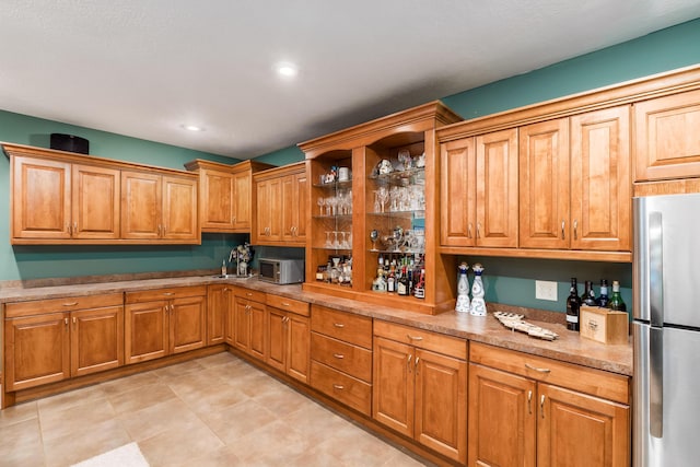 kitchen featuring light stone countertops, recessed lighting, brown cabinets, stainless steel appliances, and open shelves