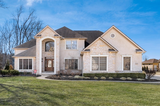 french country inspired facade featuring stucco siding, a front lawn, and a shingled roof