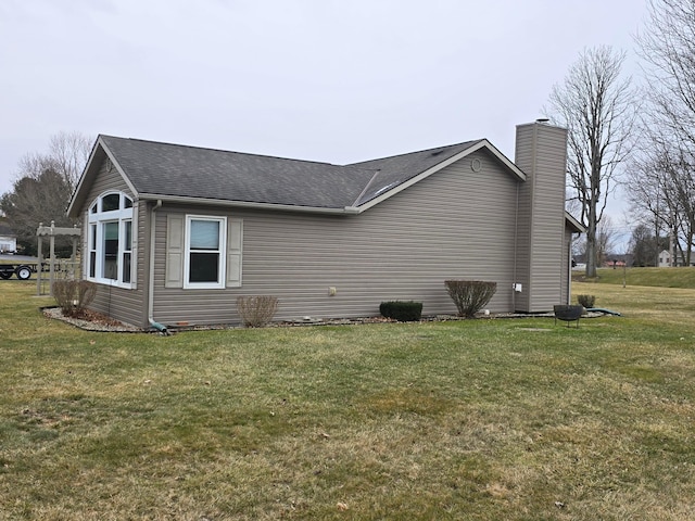 view of home's exterior with a yard, a chimney, and a shingled roof