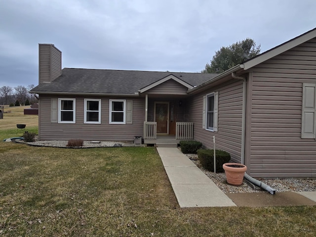 view of front of house featuring a chimney and a front yard