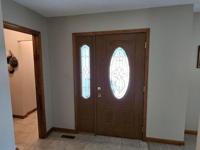 foyer entrance featuring baseboards and visible vents