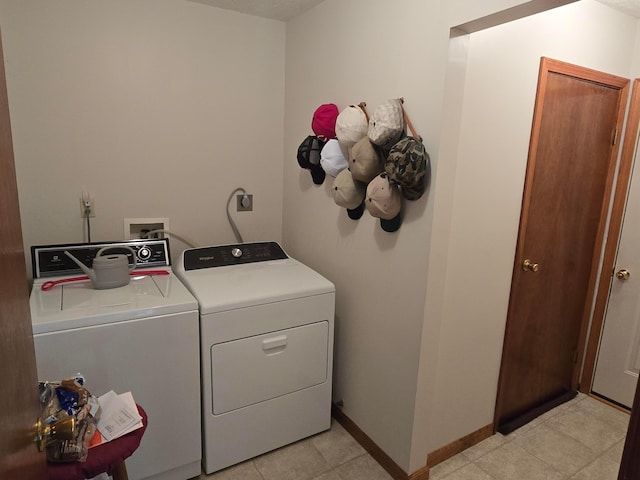 clothes washing area featuring baseboards, independent washer and dryer, and laundry area