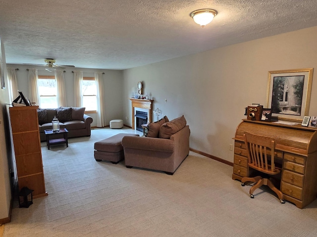 living area with a fireplace, baseboards, carpet floors, and a textured ceiling