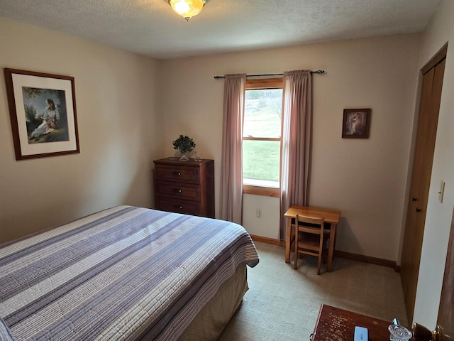 carpeted bedroom featuring baseboards and a textured ceiling