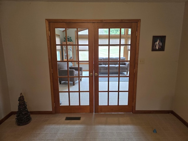 doorway featuring french doors, baseboards, visible vents, and carpet flooring