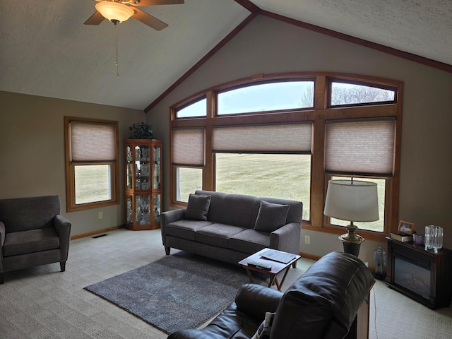 carpeted living room featuring visible vents, baseboards, lofted ceiling, a textured ceiling, and a ceiling fan