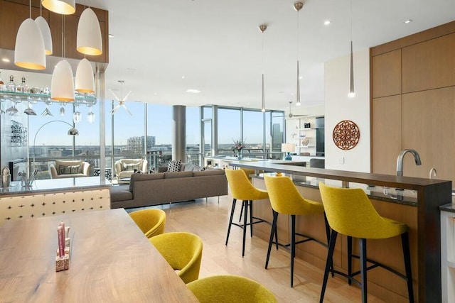 kitchen featuring a kitchen bar, a city view, expansive windows, open floor plan, and hanging light fixtures