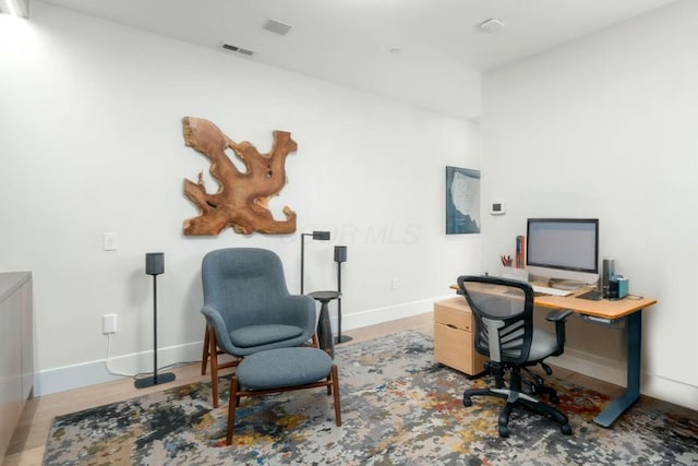 home office with baseboards and wood finished floors