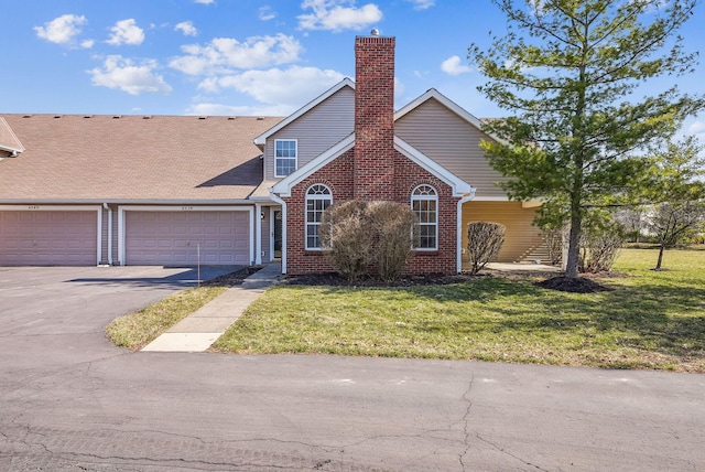 view of front facade with a front lawn, an attached garage, brick siding, and driveway