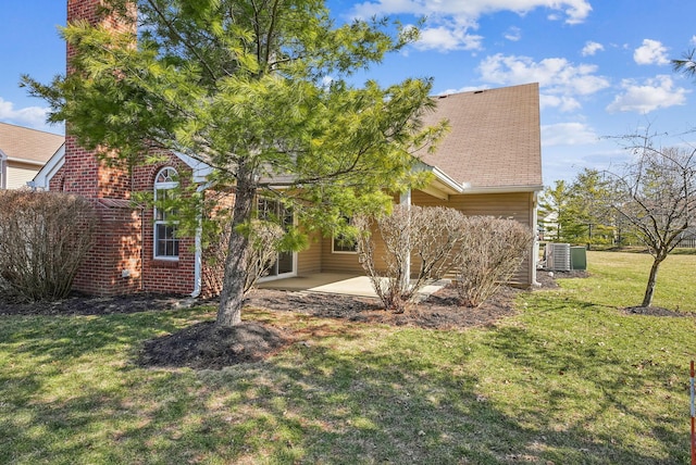 view of front of property with roof with shingles, a front lawn, central air condition unit, a patio area, and brick siding