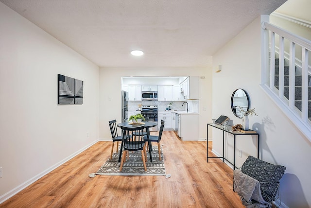 dining area featuring baseboards and light wood-style floors