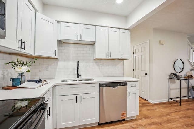 kitchen with a sink, light wood-type flooring, light countertops, and stainless steel dishwasher