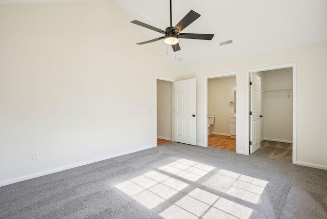 unfurnished bedroom featuring visible vents, a walk in closet, baseboards, carpet, and ensuite bath