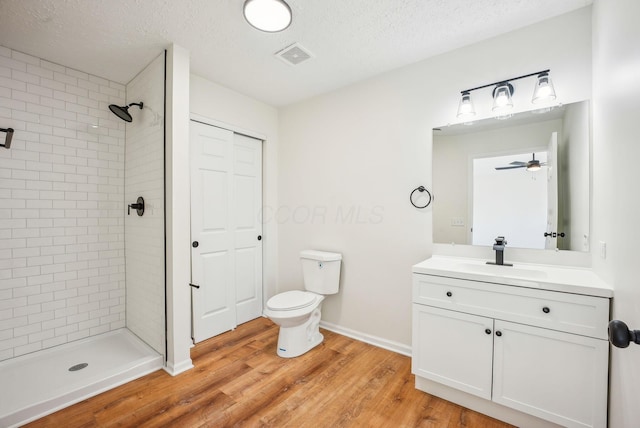 bathroom with vanity, wood finished floors, visible vents, a shower stall, and toilet