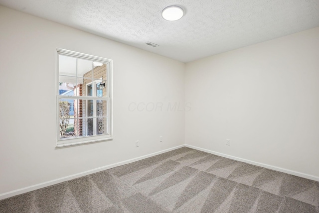 spare room featuring baseboards, carpet floors, a textured ceiling, and visible vents