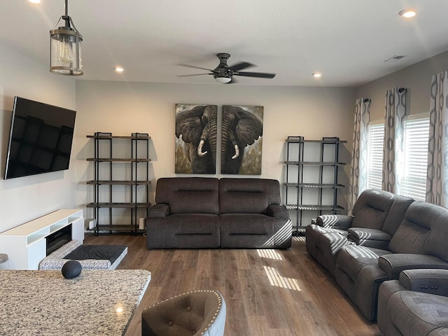 living area with recessed lighting, visible vents, wood finished floors, and a tiled fireplace