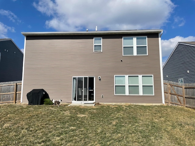 back of house with a lawn and fence