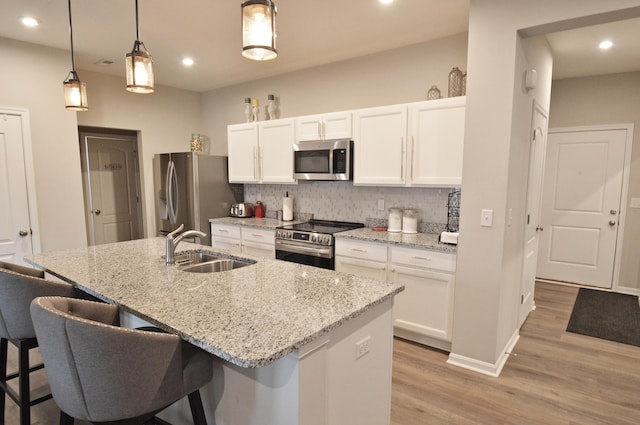 4835 Amber Crossing Dr, Columbus, OH 43232 - kitchen with white cabinetry, a sink, backsplash, and appliances with stainless steel finishes