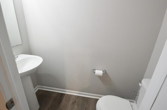 4835 Amber Crossing Dr, Columbus, OH 43232 - half bath with baseboards, wood finished floors, toilet, and a sink