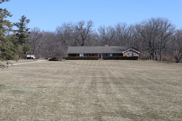 single story home with a chimney and a front yard