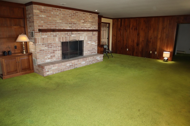 unfurnished living room featuring carpet, wood walls, crown molding, a brick fireplace, and baseboard heating