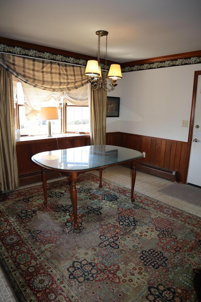 unfurnished dining area featuring a baseboard radiator, a notable chandelier, wood walls, and wainscoting