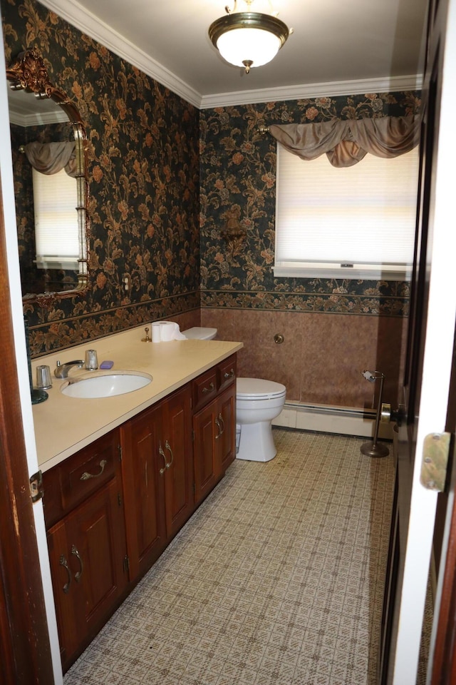 bathroom featuring wallpapered walls, a baseboard heating unit, crown molding, toilet, and vanity