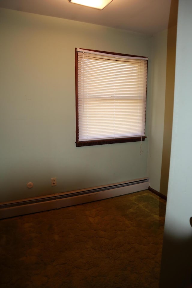 unfurnished room with a baseboard heating unit and baseboards