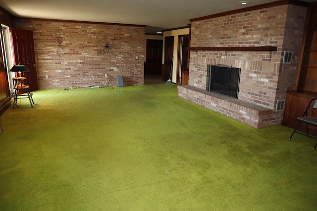 unfurnished living room with a brick fireplace, brick wall, crown molding, and carpet