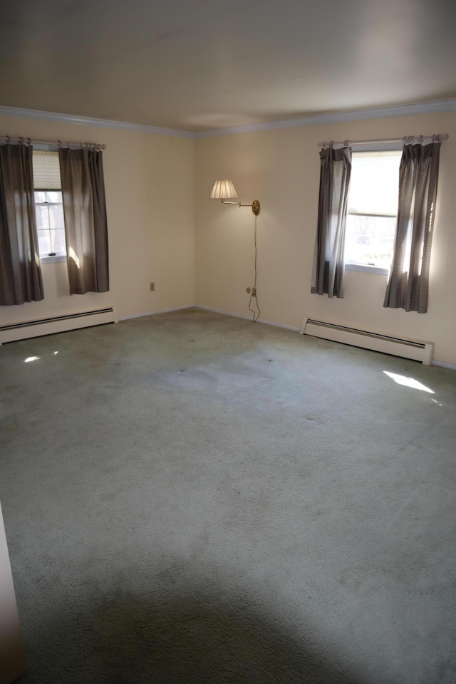 spare room featuring crown molding, a healthy amount of sunlight, and baseboard heating