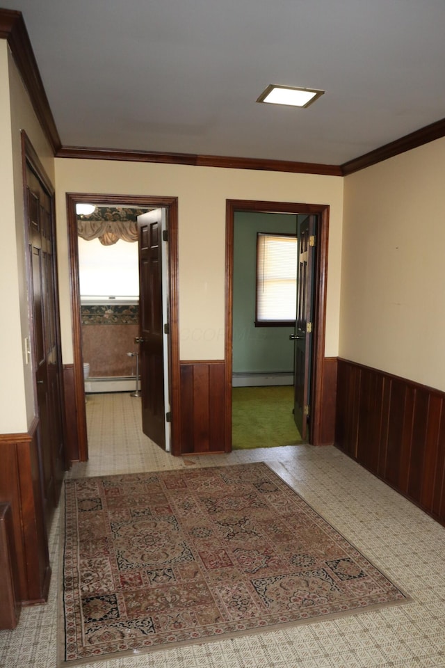 hallway featuring a wainscoted wall, wood walls, and a baseboard radiator