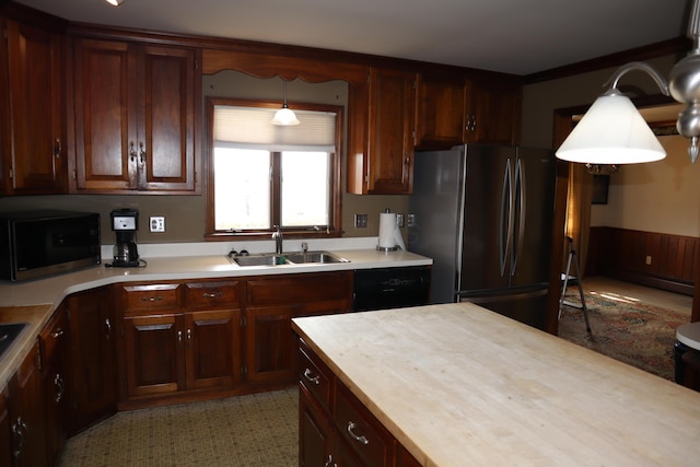 kitchen with light countertops, freestanding refrigerator, black dishwasher, and a sink