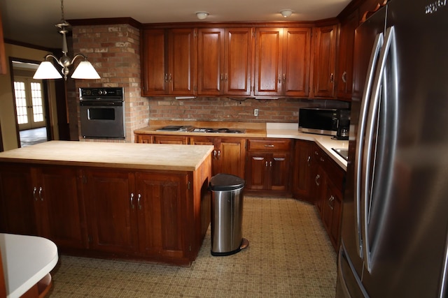 kitchen featuring a notable chandelier, decorative light fixtures, a center island, appliances with stainless steel finishes, and wooden counters