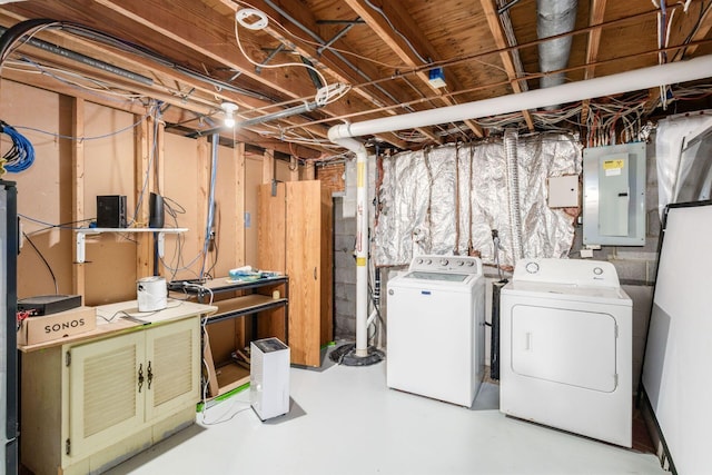 unfinished below grade area featuring electric panel and independent washer and dryer