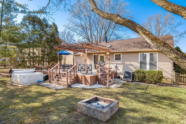 rear view of property with a wooden deck, a lawn, a pergola, and an outdoor fire pit