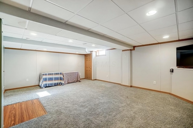 unfurnished bedroom with a drop ceiling, baseboards, and carpet flooring