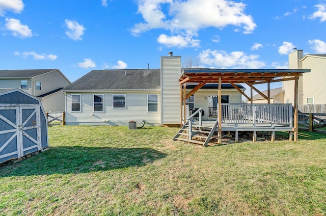 back of property with fence, a storage shed, an outdoor structure, a wooden deck, and a chimney