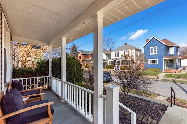 wooden terrace featuring covered porch and a residential view