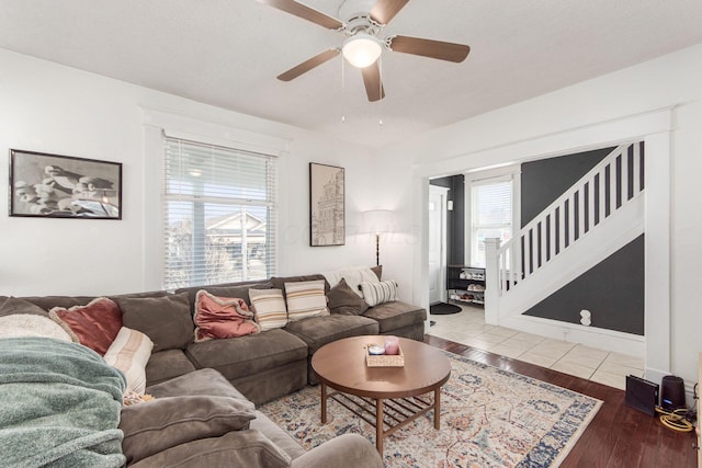 living room featuring stairs, hardwood / wood-style flooring, and ceiling fan