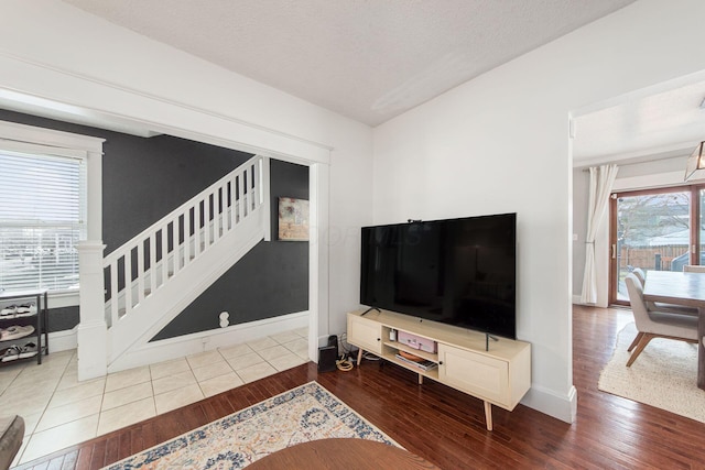 living area featuring stairs, hardwood / wood-style flooring, and a textured ceiling