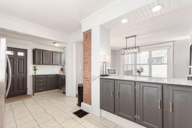 kitchen with light stone counters, light tile patterned floors, stainless steel appliances, hanging light fixtures, and crown molding