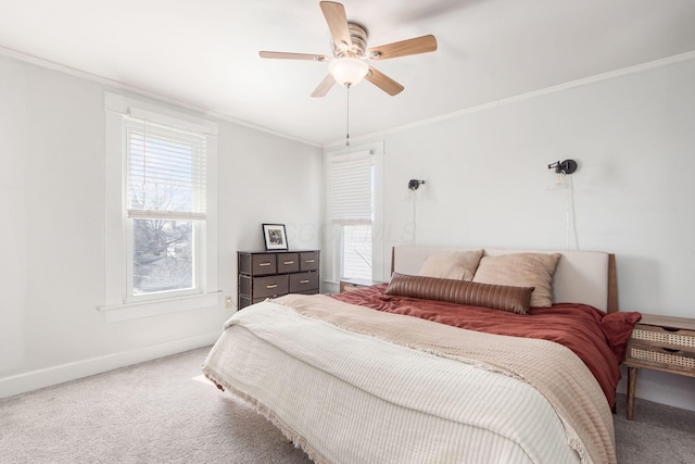 carpeted bedroom with ceiling fan, baseboards, and ornamental molding