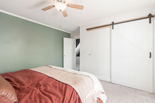 bedroom featuring carpet, baseboards, ceiling fan, ornamental molding, and a barn door