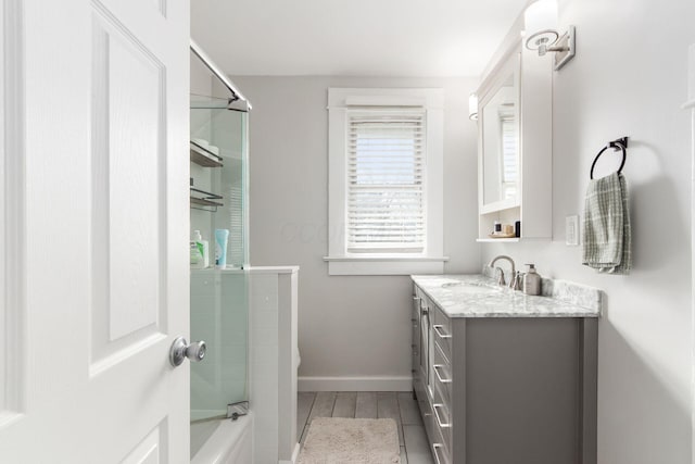 bathroom with vanity, wood finished floors, and baseboards