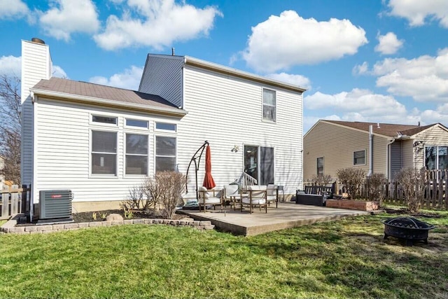 back of property featuring a patio, an outdoor fire pit, a yard, cooling unit, and a chimney