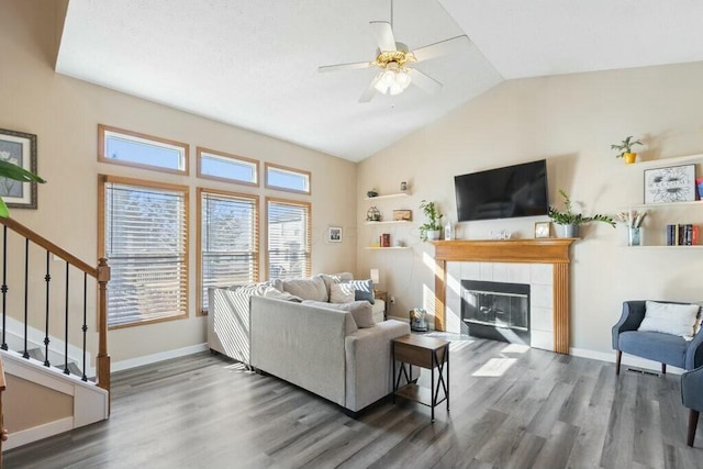 living area with stairway, lofted ceiling, baseboards, and wood finished floors