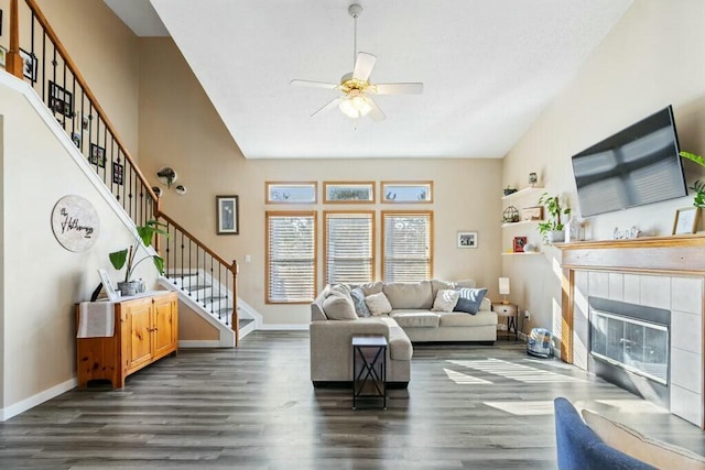 living room with stairway, baseboards, and dark wood-type flooring