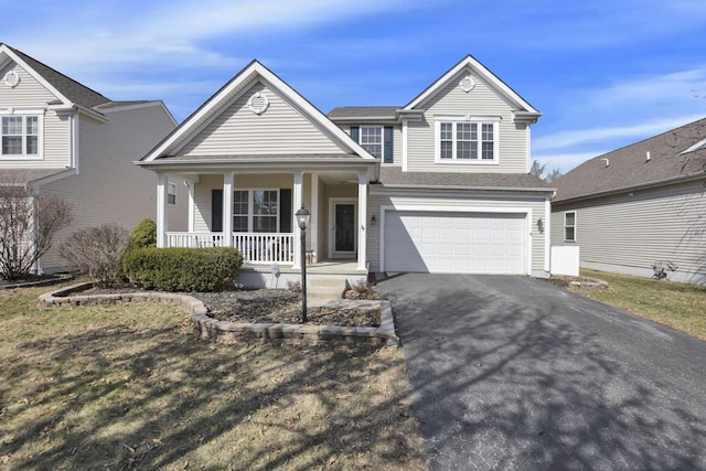 traditional-style home with an attached garage, covered porch, and driveway