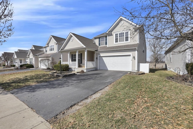 view of front of house with a front lawn, driveway, a residential view, covered porch, and a garage