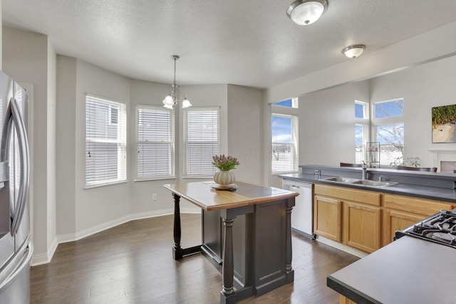 kitchen with a sink, dishwasher, a healthy amount of sunlight, and freestanding refrigerator